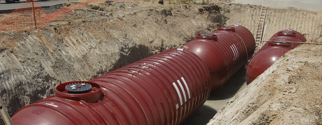 Three red underground fuel storage tanks