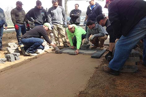 Students begin laying stones in a new walkway