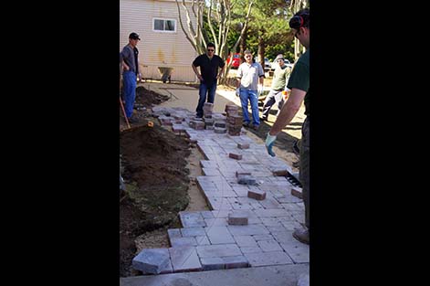 Students work on building concrete paver walkway