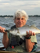 EPH Environmental Enforcement Faculty Coordinator Joe Mikulka holding fish with water in background