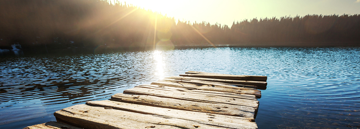 Lake with dock at sunset