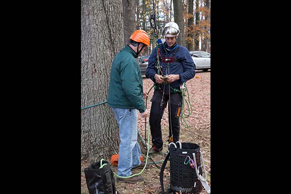 Instructor Steve Chisholm assists his brother and fellow instructor Mark Chisholm in preparing for his climb