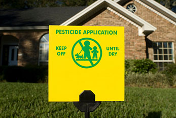 Pesticide application sign on lawn in front of home