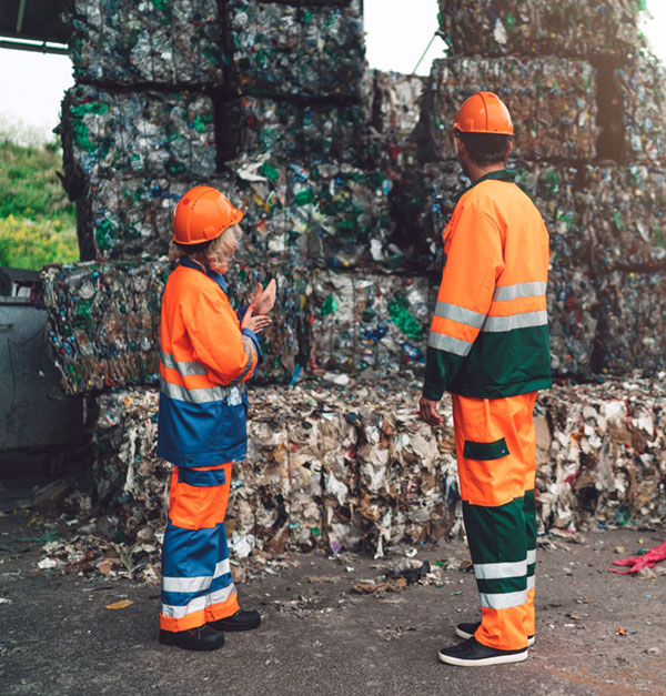 Recycling center workers examining paper waste ready for recycling