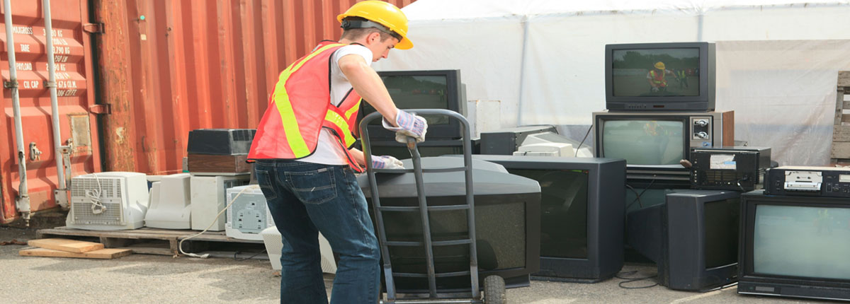Recycling Worker moving large television with handcart