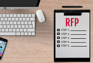 Clipboard with RFP steps on desk next to computer keyboard