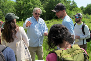 Wetlands course instructor Ralph Tiner showing students a wetland plant