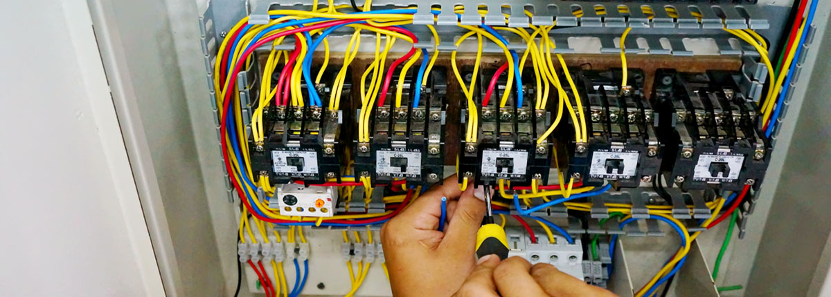 Electrical contactor doing wiring work in motor control panel