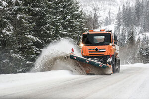 Snow plow truck clearing snow from roadway
