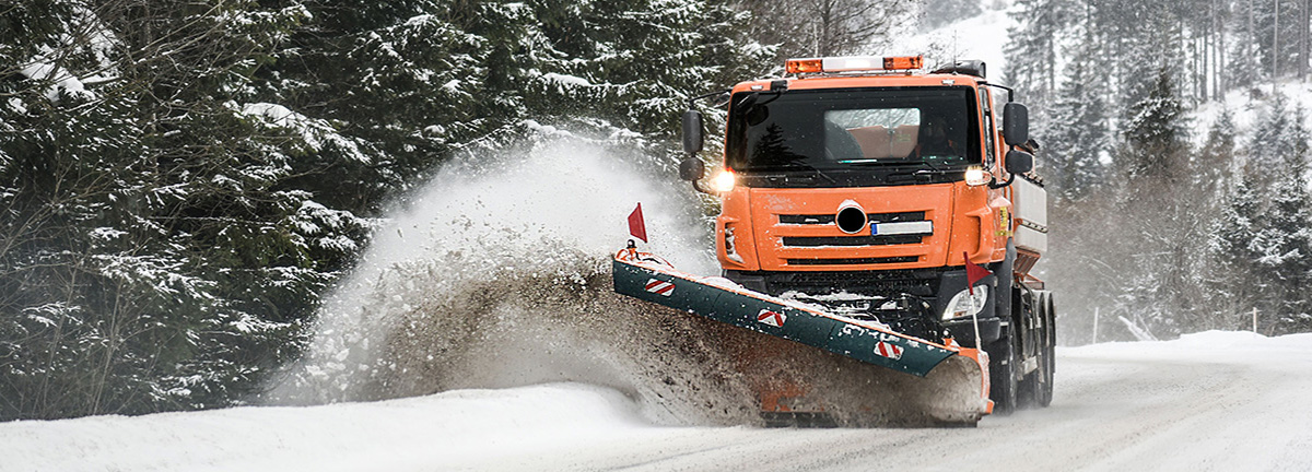 Snow plow truck clearing snow from roadway