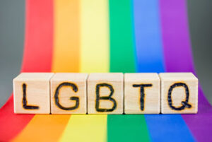 Blocks with LGBTQ letters on rainbow background