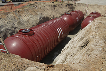 Three red underground fuel storage tanks