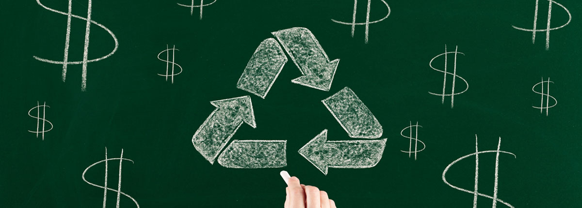 Recycling symbol and dollar signs written on chalkboard